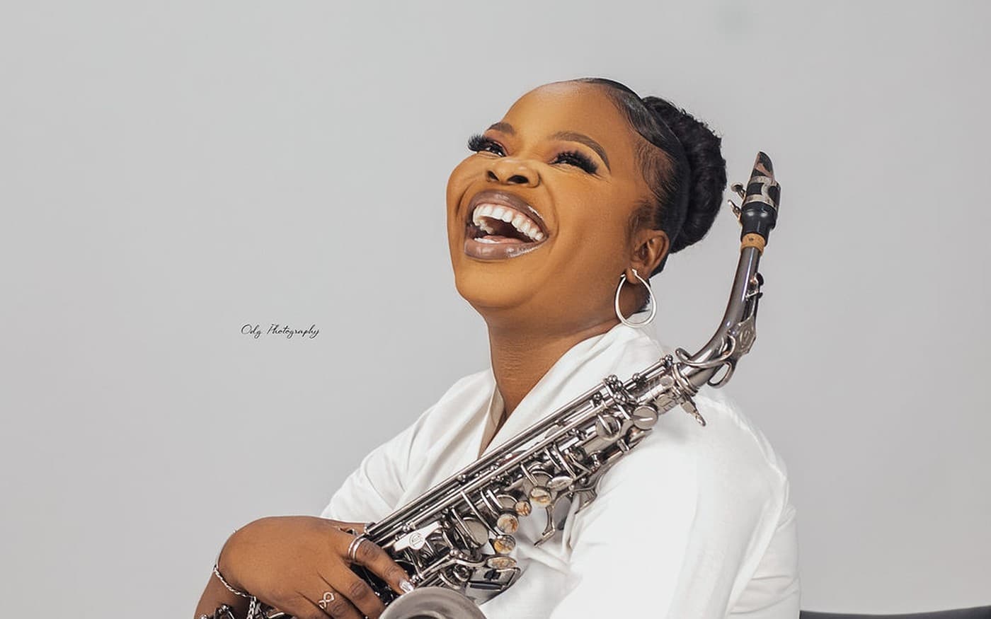 Funmisax laughing with saxophone