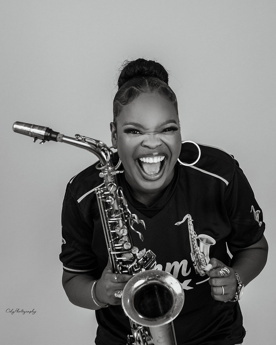 Black and white portrait of Funmisax laughing with her saxophone